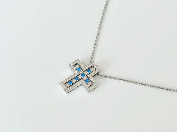 Layered sterling silver cross necklace: Rhodium-plated openwork cross with clear diamonds suspending blue gemstone cross on 17.7" rope chain, RSL compliant