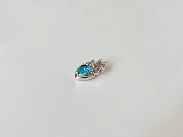 Side view of teardrop blue CZ heart pendant showing 925 rhodium-plated setting and brilliant-cut clear zirconia stones